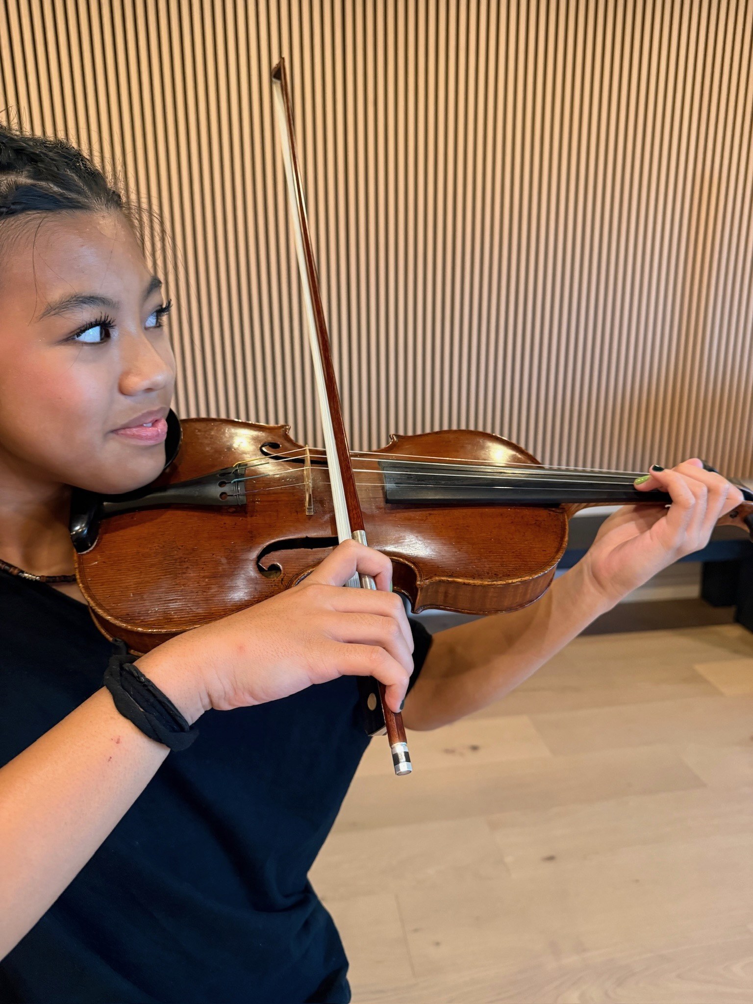 Young violinist playing, eyes on her bow